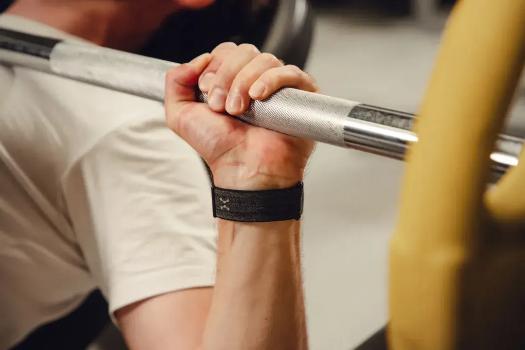 Wrist gripping a barbell wearing the Hume Band — blood-pressure trend across days